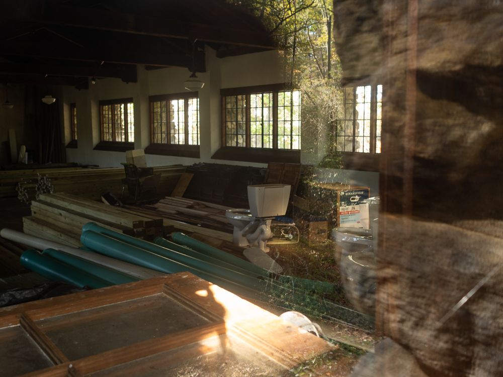 a toilet and construction materials through a window in a large stone building