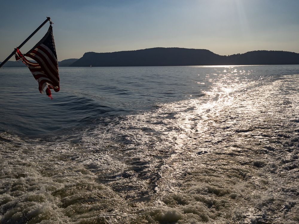 the tattered American flag on the Haverstraw-Ossining ferry and its wake