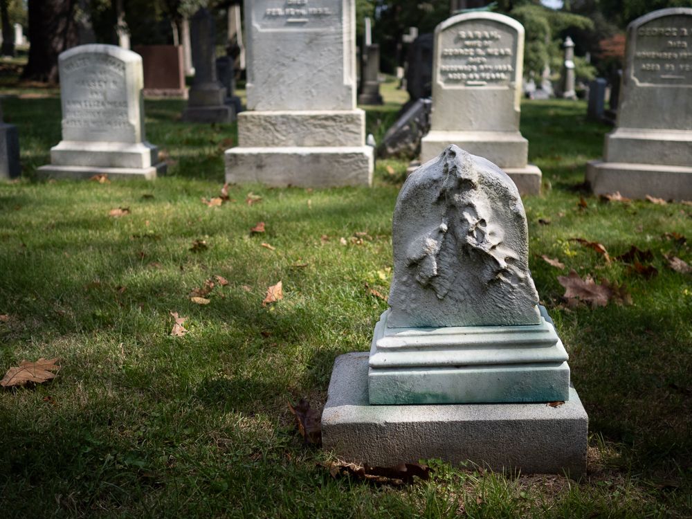 a small, melting headstone in Greenwood Cemetery