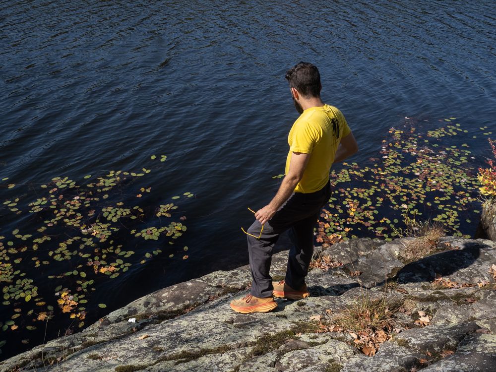 Michael holding his yellow-framed sunglasses contemplates swimming in Lake Kanawauke