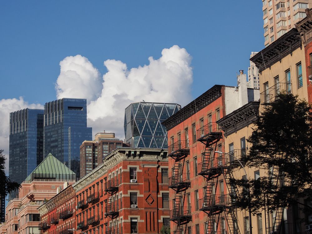 A cumulous cloud peeking out over some buildings in Hell's Kitchen