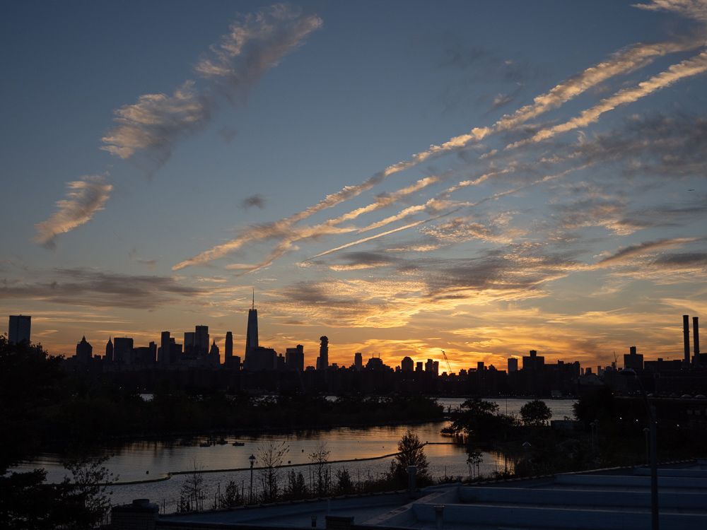 a sunset behind manhattan from a greenpoint rooftop